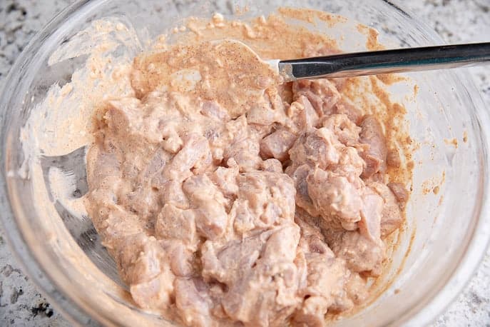 chicken in cream cheese mixture in a glass bowl with spatula