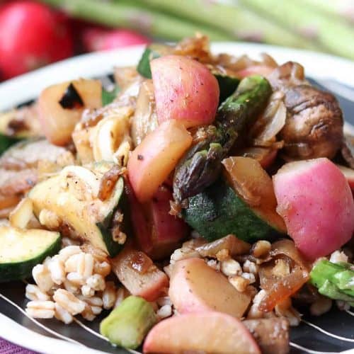 radishes, zucchini, asparagus on top of farro