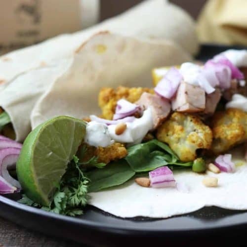 cauliflower wrap on a plate with lime and onion