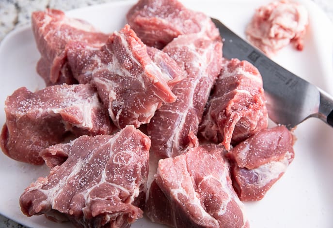 pork pieces on a white cutting board