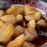 cooked apples in a decorative bowl with spoon