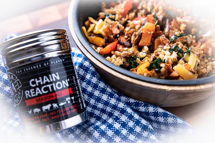 Chain Reaction spice next to a breakfast bowl on a blue checkered cloth