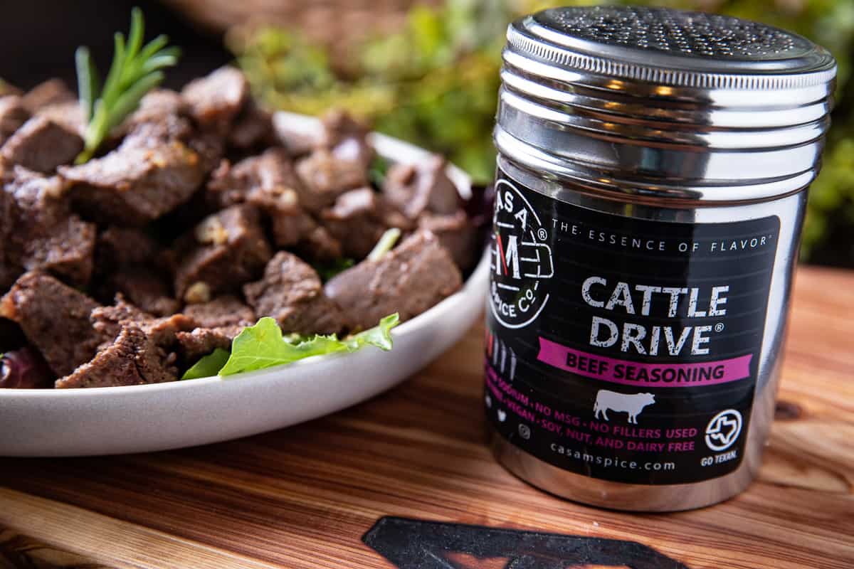 Cattle Drive spice in a tin, plate of steak bites on a board