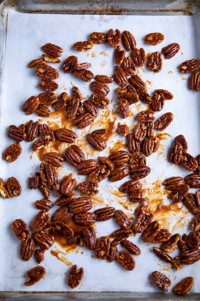 spicy pecans on a baking sheet with parchment paper