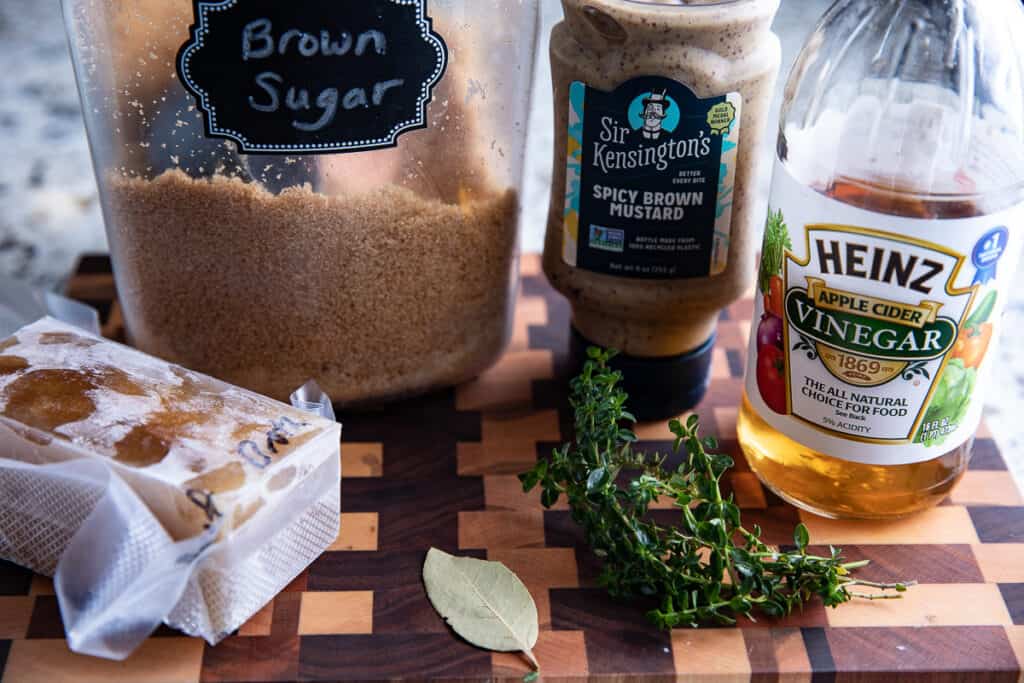 brown sugar, mustard, vinegar, thyme, broth, bay leaf on a wooden board