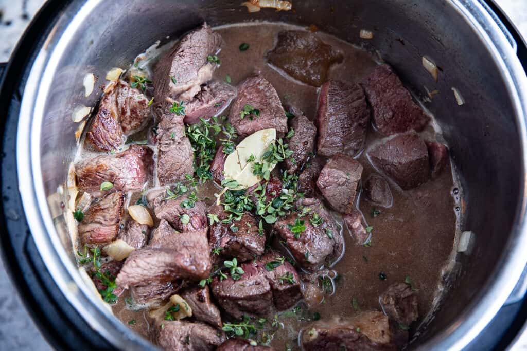 beef, beer, thyme and bay leaf in Instant Pot