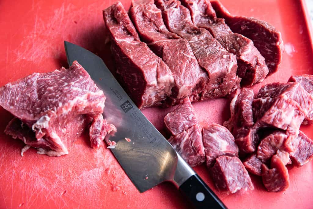 raw meat on a cutting board with knife