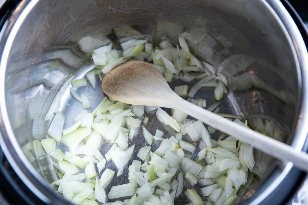 onions in an Instant Pot with spoon