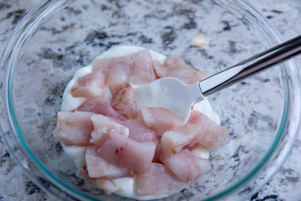 raw chicken in a bowl with yogurt