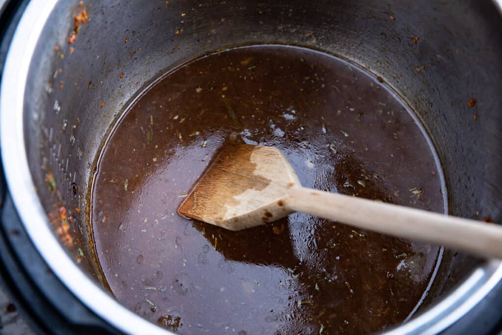gravy in Instant Pot with wooden spoon