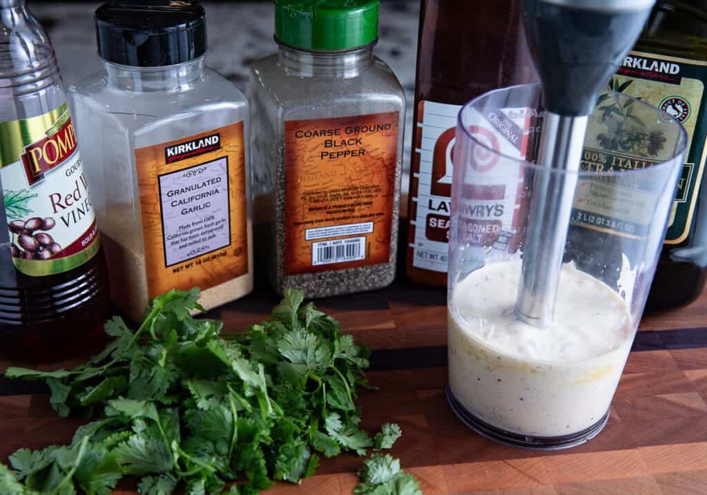 spices and cilantro on board with immersion blender and dressing