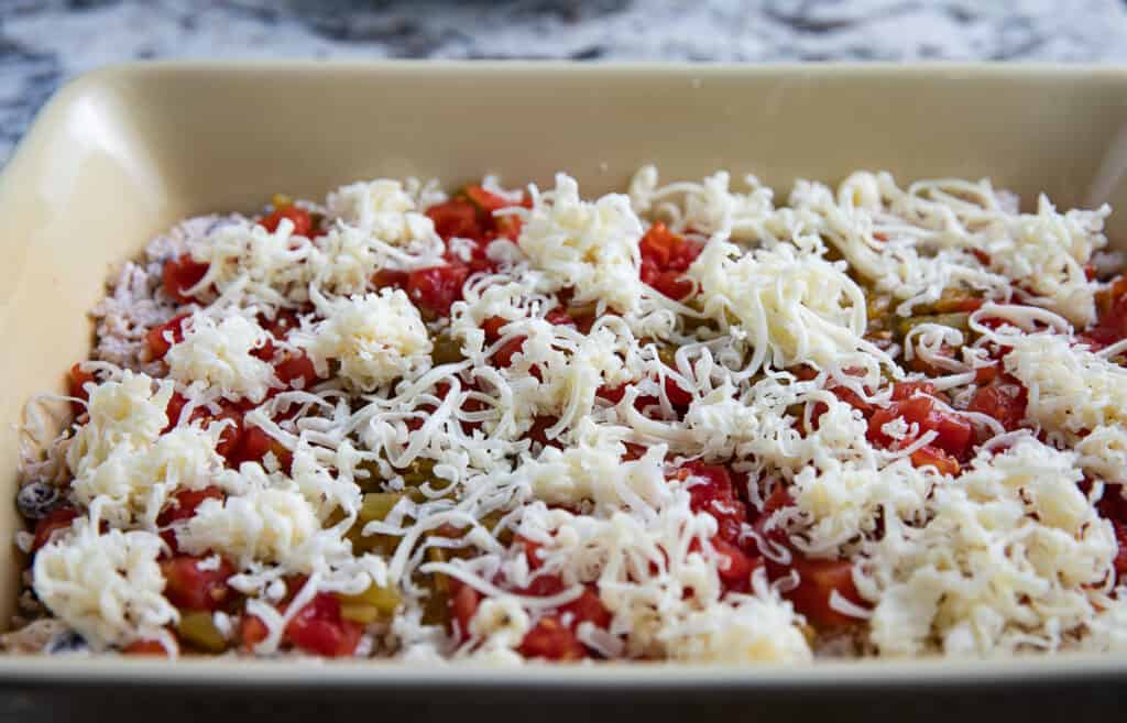 casserole dish with cheese, tomatoes, green chiles