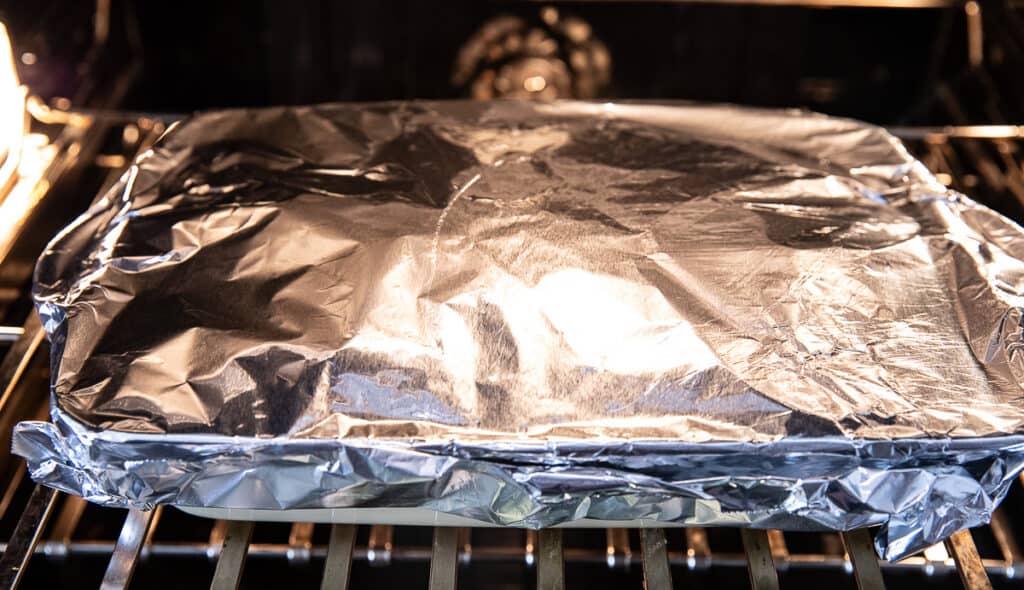 casserole in oven wrapped with foil