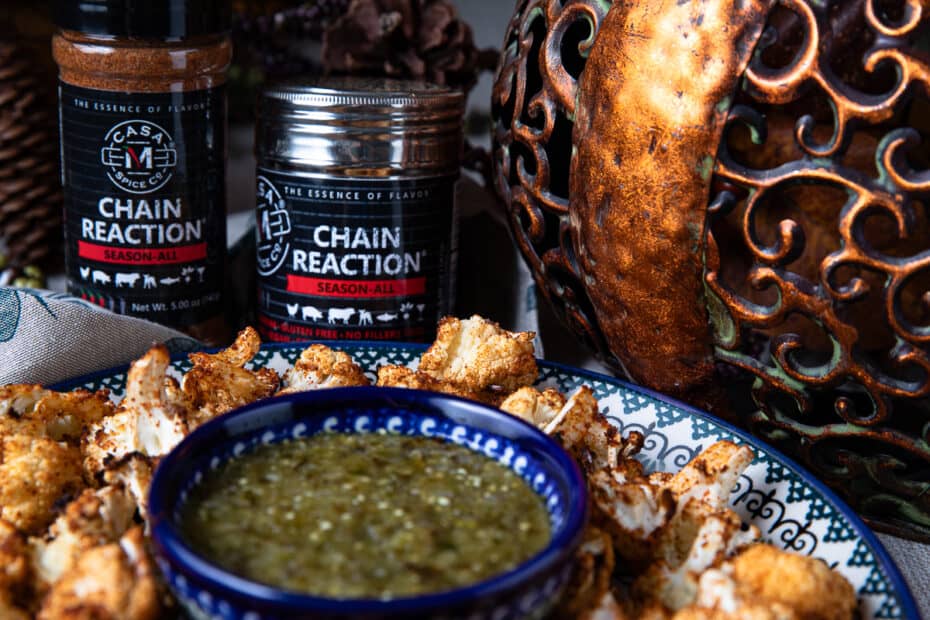 Chain Reaction Spice behind a plate of roasted cauliflower with salsa, fall decor