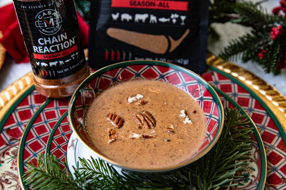 soup in a bowl with pecans and spice jar