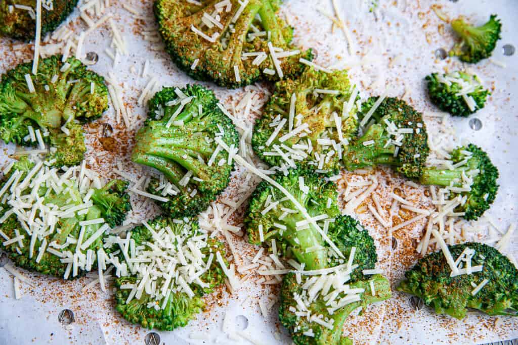 broccoli on parchment paper with spice and cheese