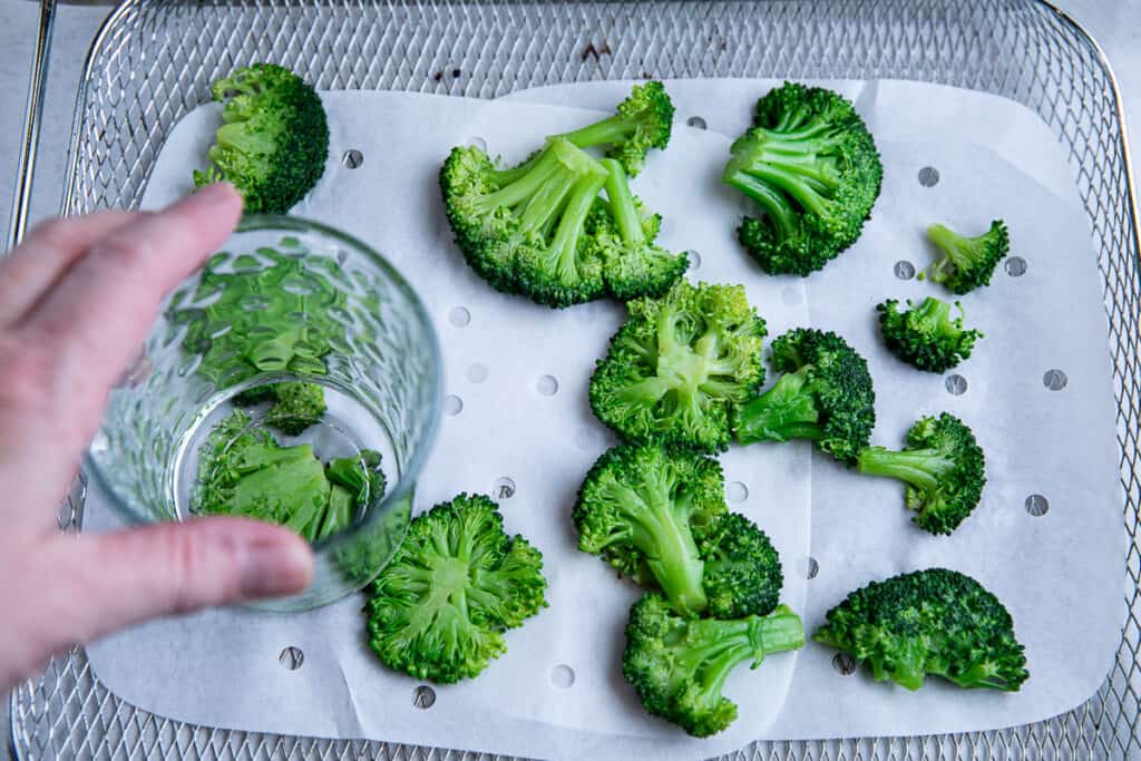 hand holding glass smashing broccoli