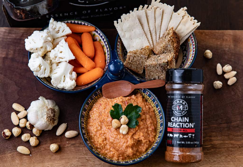 romesco sauce in a bowl with spices, cauliflower, carrots, bread