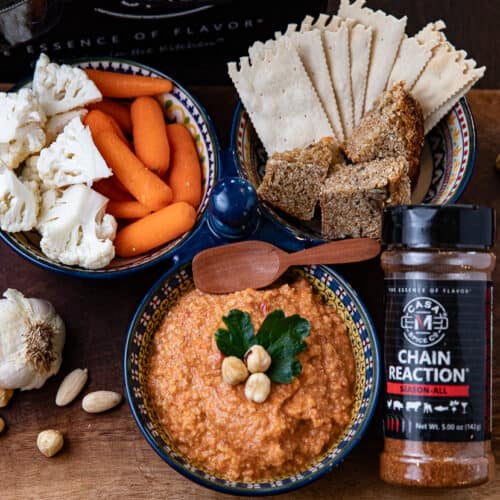 romesco sauce in a bowl with spices, cauliflower, carrots, bread